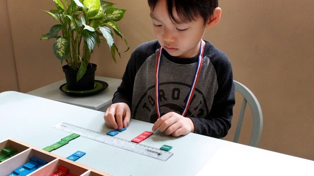 A little boy plays with educational tiles