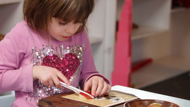 Little girl slicing an apple